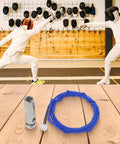 Blue wire and tip set on wooden floor; backdrop of fencers in duel, focus keyword: Wire And Point Tip Set For Fencing Epee Repair With High Conductivity Metal Wire For Training And Competition Easy Install And Quick Swap For Replacing Epee Accessories And One Meter Lead Line.