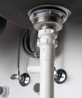 Under-sink view showing a white Dishwasher Drain Branch Tailpiece, One And One Half Inch Inlet, Eight Inch Long, Three Quarter Inch OD Branch