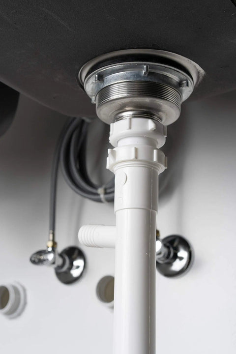 Under-sink view showing a white Dishwasher Drain Branch Tailpiece, One And One Half Inch Inlet, Eight Inch Long, Three Quarter Inch OD Branch