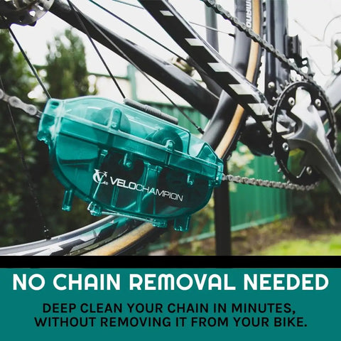 Green Handheld Bike Chain Cleaner Tool attached to bike chain for quick efficient clean, no chain removal needed, outdoor setting.