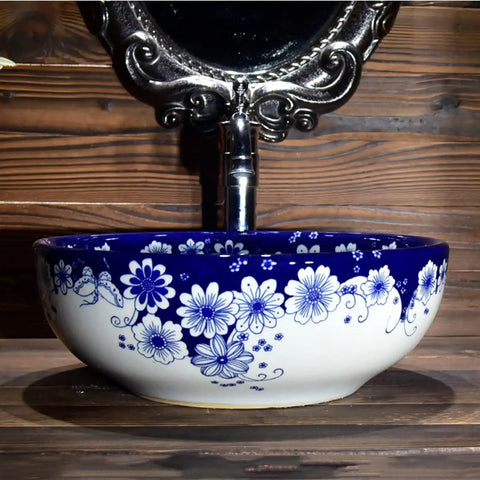 USZWBY Vessel Sinks Blue and White Porcelain Bathroom Basin Sink round ceramic sink with floral design and faucet.
