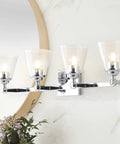 Chrome 4-Light Vanity Light Wall Sconce with clear seeded glass shades, reversible mount in a bathroom setting, 28.5 inch long.