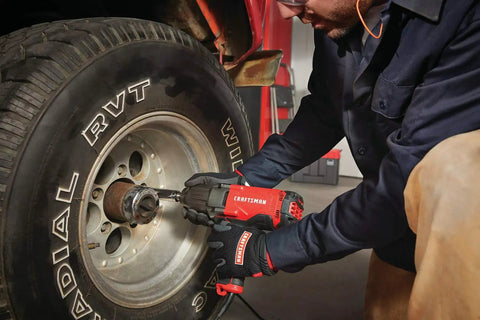 Mechanic using Half Inch Corded Impact Wrench, 7.5 Amp Power, 450 Ft Lbs Max Torque, 2700 IPM on car wheel lug nut
