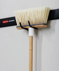 Broom mounted on FastTrack Wall Mounted Utility Hook for Rope Hose and Tools Garage Storage With Soft Grip Coating Mounted to rail