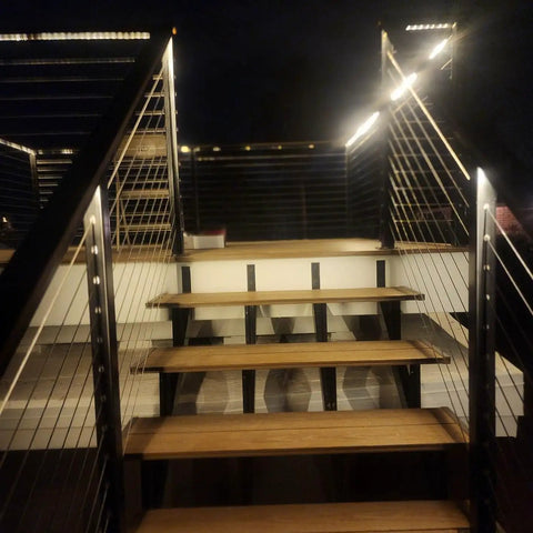 Night view of deck stairs with 1/8 Black Stainless Steel Cable 500 ft Heavy Duty 7x7 Core for DIY deck railing and outdoor use.