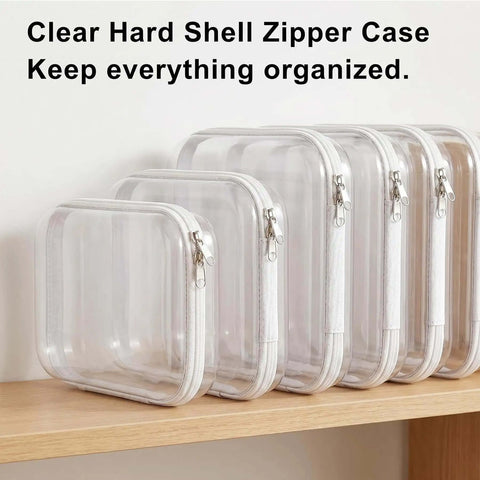 Clear Hard Shell Makeup Pouch Set, Transparent Cosmetic Organizers, Crush Resistant Travel Toiletry Cases, Durable zippered cases lined up on shelf.