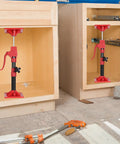 Cabinet jacks for installing cabinets: red and black adjustable support poles mounted in two cabinet openings; 2-pack.
