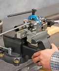 Rock Solid Five Inch Workbench Vise With Knockout Grip Smooth Non Marring Jaws And Heavy Duty Locking Mechanism in use on a wooden bench.