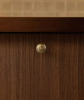 Real Deal Antique Brass Cabinet Knobs 1 1/4 Inch Round Sunburst Design on a wooden cabinet door.