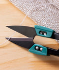 Close-up of 4.2 Inch Ultra Sharp Sewing Scissors With Wide Handle For Easy Grip Thread Snips Two Pack cutting fabric.