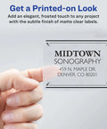 Full-sheet clear shipping label with Midtown Sonography address printed, held by a hand