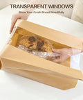 Hands placing bread into 100 Pack Bread Bags With Clear Window And 120 Stickers For Homemade Bread Storage Sourdough Bread Bags For Bread Cookies And Snacks In Large Bakery Paper Bags