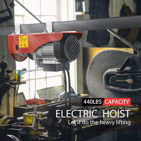 Installed red electric hoist mounted on overhead beam with cable and hook, 440 lb capacity