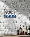Must Wear Protective Equipment Area Aluminum Sign 8x12 Inch on white brick wall above bottles