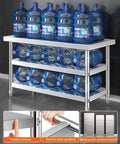 Beefy Stainless Steel Workbench With Three Tier Open Shelving And No Fuss Leveling Feet Built Tough Kitchen Prep Table Or Packing Station For Real Garage Workshop Days with water bottles on shelves.
