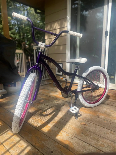 Purple BMX bike with white tires featuring a swallow shaped high carbon BMX handlebar 585mm long with 22.2mm clamp for small kid bikes.