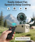 Camping Fan With Remote Control And 12000mAh Battery LED Light Hanging Hook Rechargeable Battery Operated Tent RV Fan For Bed Or Camp Three Quiet Speed Settings Portable Battery Powered Ceiling Style Fan Green in outdoor setup with remote shown in hand.