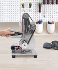 Rock Solid Mini Belt Sander With Seven Adjustable Speeds For Smooth Wood Finishing And Polishing Hella Durable Stainless Steel Bench Grinder Buffing Rig For Weekend Warrior Workshops, compact sander with rocks being polished.