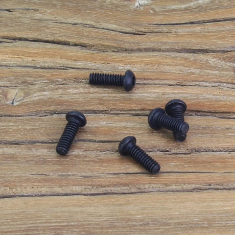 105 Piece M2 X 6mm Button Head Socket Cap Screws scattered on wooden surface showing black oxide finish and fully threaded shafts.