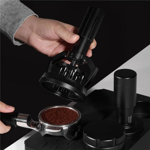 Hand holding a 58mm Electric Espresso Stirrer And Wdt Tool With Fine Needles over a portafilter filled with coffee grounds.