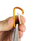 Hand holding Outdoor Knot Cards 22 Knots For Camping Backpacking And Scouts Easy Step By Step Diagrams And Real World Tips with carabiner clip.