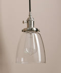 Close-up of one light from the Three Light Industrial Pendant Lighting for Kitchen Island with Oval Clear Glass Shades, Brushed Steel Ceiling Fixture
