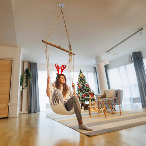 Woman sitting in a swing with Beast Mode Heavy Duty Two Pack Wall Mount Brackets For Suspension Straps Gym Rings And Body Weight Training With Industrial Steel Ceiling Anchors Supporting Up To Seven Hundred Fifty Pounds.