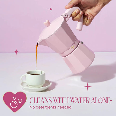 Pink Stovetop Espresso Maker 6 Cup Moka Pot With Heart Knob For Rich Aromatic Espresso At Home Italian And Cuban Style Coffee Pot Great For Coffee Lovers being poured into a cup