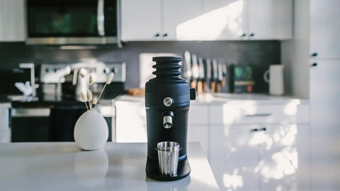 Game Changing Single Dose Coffee Grinder With 64 Millimeter Flat Burrs Stepless Adjustment Heavy Duty Zero Retention Build For Killer Espresso At Home Quiet Compact Design In Crisp White Finish on countertop.