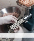 Gloved hands using set of 4 stainless steel sausage stuffer tubes with 15mm 19mm 22mm 28mm nozzles for meat grinder