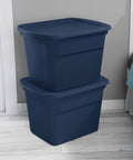 No Sweat 18 Gallon Plastic Storage Totes With Secure Snap Lids 32 Pack stacked navy bins in a bedroom for organizing clothes.