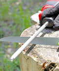 Hunters Field Dressing Kit 10 Piece Portable Game Processing Set sharpening knife on a tree stump outdoors
