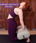 Woman using EZ Clean Standard Yoga Bolster Taupe Firm and Supportive Handmade in USA with Durable Eco Vinyl during a yoga session.