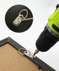 Heavy Duty D Ring Steel Picture Hangers With Screws 20 Pack Double Hole Clips being mounted on a frame with a drill