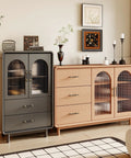 Modern living room with black and gold cabinet pulls on wooden cabinets and drawers, featuring decorative vases and artwork on top.