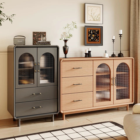Modern living room with black and gold cabinet pulls on wooden cabinets and drawers, featuring decorative vases and artwork on top.