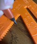 Close-up of 8 Inch Orange Composite Speed Square Layout Tool With Center Line Guide Beveled Edge And One Eighth Inch Notches.