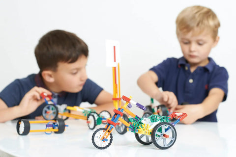 STEM Vehicle Building Kit With 130 Plus Parts For Kids Ages 8 And Up, Build 7 Hands-On Vehicles Powered By Push, Rubber Band, Wind Or Spring Motor, Learn Potential And Kinetic Energy, Velocity, Acceleration, Motion, And Graphing Concepts, two boys building models