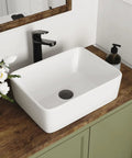 Upgrade Your Powder Room With This Sleek White Ceramic Vessel Sink Measuring 16 By 12 Inches For A Modern Rectangle Basin Setup Featuring Slick Glossy Finish And Hella Durable Build on a wooden countertop.