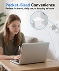 Young woman using laptop with Small European To American Outlet Plug Adapter For Europe To USA Canada Travel Power Plug Schuko Type E And Type F Compatible White Ultra Compact 1 Pack Easy Plug In For Multi Device Use plugged into wall.