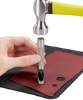 Using 12 Piece Hollow Leather Punch Set Made Of Steel on leather material with a hammer for precise crafting.