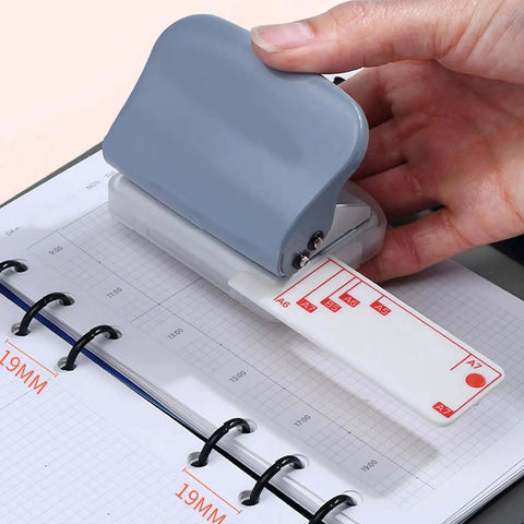 Person using Beefy 3 Hole Punch For Scrapbooks And Documents With Metal Body And Positioning Posts on a loose leaf page