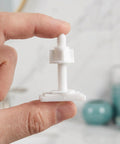 Hand holding a white bolt from a 10 Piece Toilet Seat Bolt Kit With Plastic Screws Nuts And Washers For Universal Toilet Lid Fit