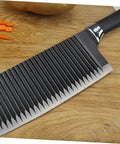 SOLUSTRE wavy crinkle slicer knife with stainless steel blade and black handle on wooden cutting board