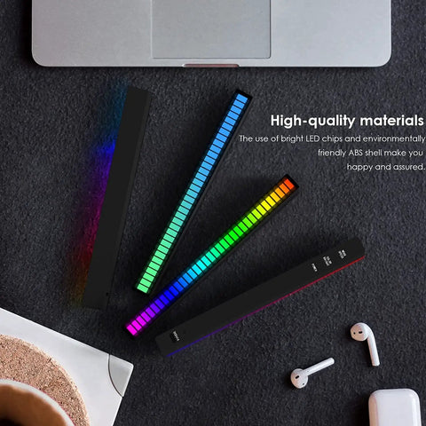 Top view of RGB Rechargeable Sound Control Lights With Voice Activated Music Rhythm set next to laptop on dark surface