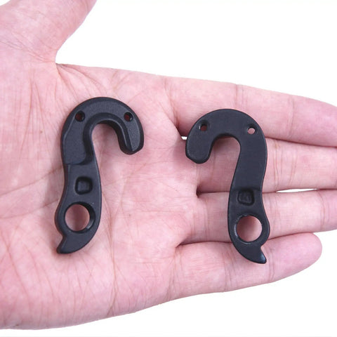 Hand holding two Derailleur Hanger 290 Dropout 475 Compatible With Giant Contend TCR Propel Forma Idiom Langma Liv Advanced CNC Aluminum Alloy Gear Mech Hanger Replacement With M3x8 Screws High Strength Durable Bike Parts