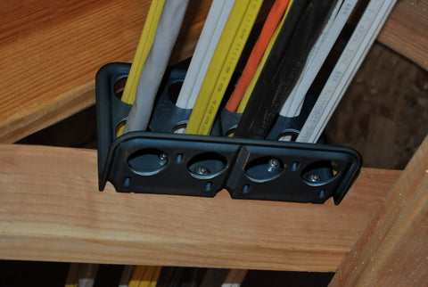 Box Of Fifty H2 Homer Helpers For Electrical Wire Management, black plastic cable organizer with wiring, mounted on wooden beam.