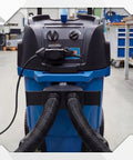 Industrial vacuum cleaner in workshop setting with dual hose system for dust collection, compatible with 2.5-inch hoses.