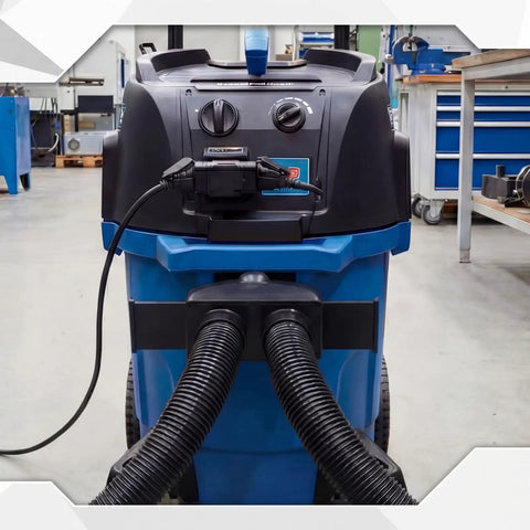 Industrial vacuum cleaner in workshop setting with dual hose system for dust collection, compatible with 2.5-inch hoses.