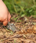 Hand using Lightweight Folding Shovel For Camping And Gardening Handy Compact Trowel Tool to dig in the soil